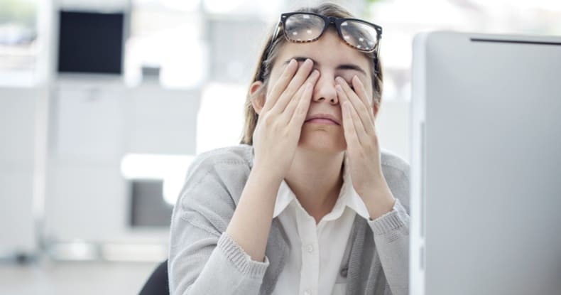 Persona con malestar frente a laptop - Estrés financiero