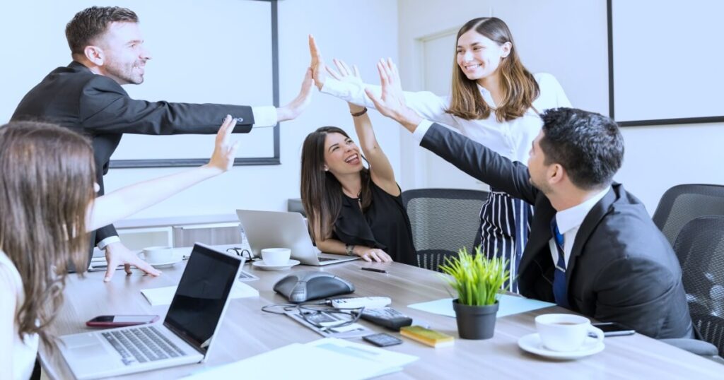 Equipo de trabajo motivado celebrando un logro en la empresa
