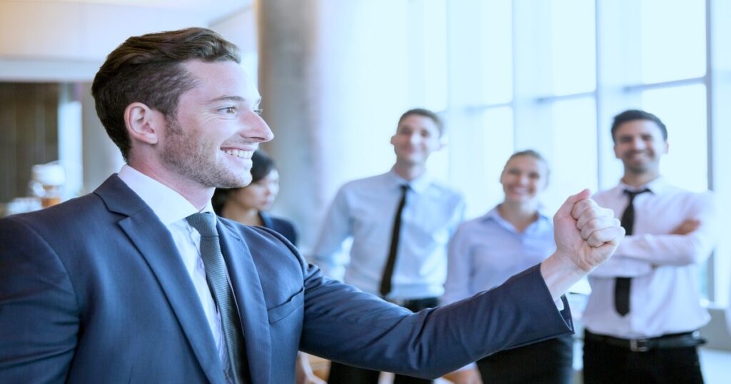 Líder motivando a empleados en sala de juntas con actitud positiva y profesional