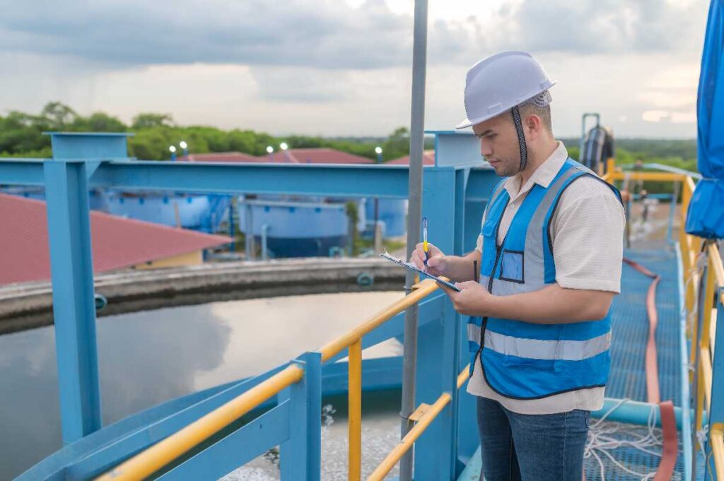Ingeniero supervisando el flujo de agua tratada en una planta de tratamiento industrial.