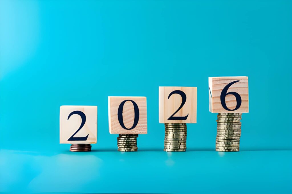 4 dados de madera con los números 2, 0, 2, 6 sobre pilas de monedas ascendentes