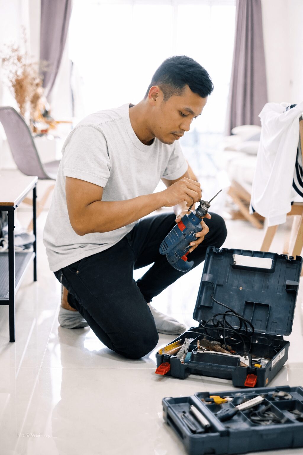 Persona preparando el uso de un taladro en una casa