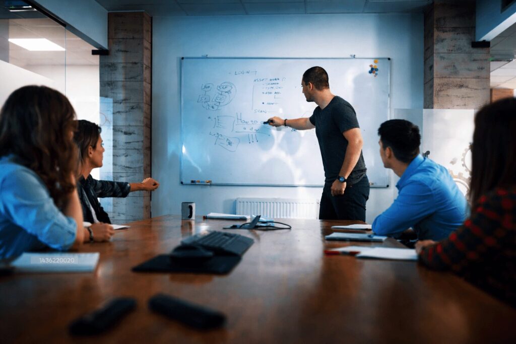 Hombre explicando un proyecto a personas en una sala de juntas