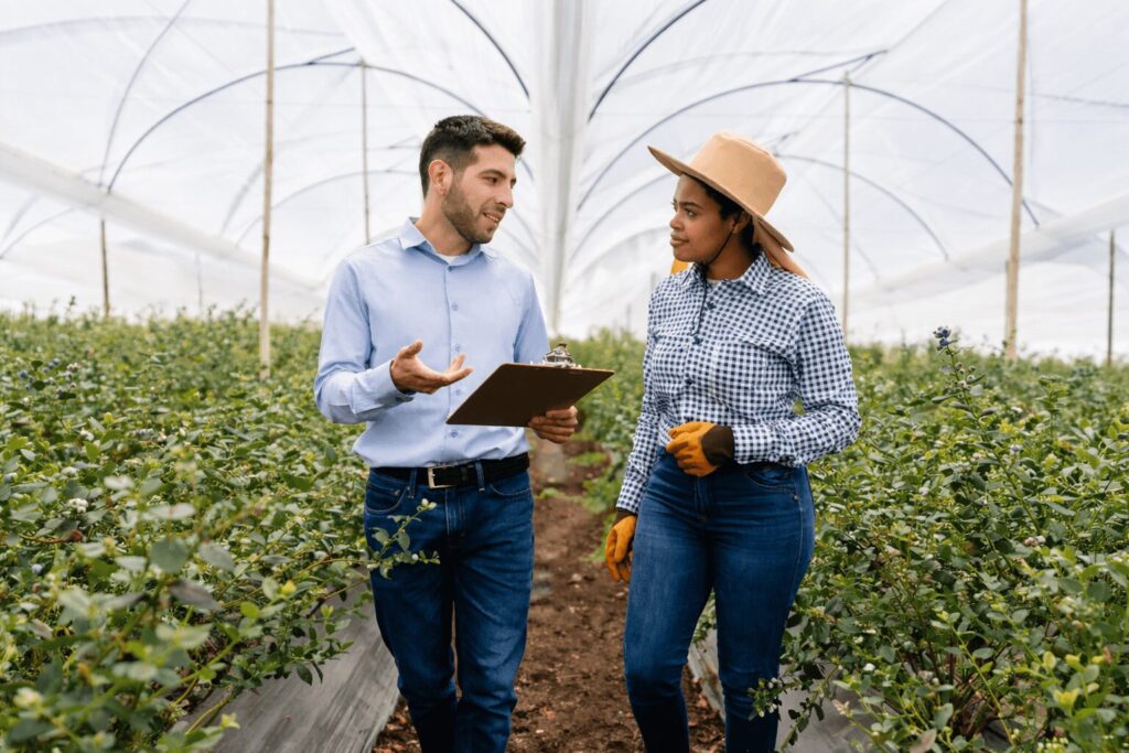 Hombre y mujer platicando dentro de un invernadero